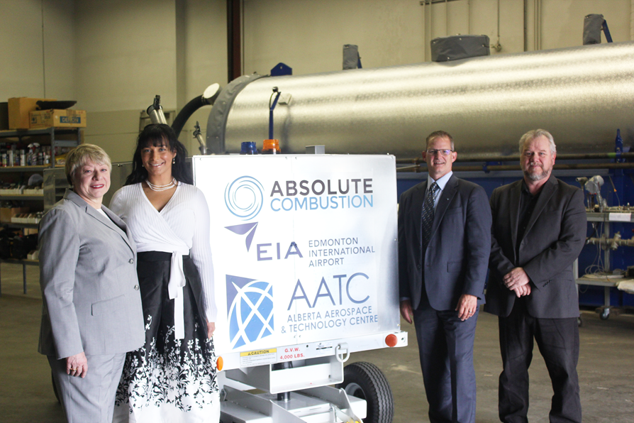 Laura Kilcrease, CEO of Alberta Innovates, Koleya Karringten, CEO of Absolute Combustion International, Steve Maybee, VP of Operations and Infrastructure, Edmonton International Airport and Rollie Dykstra, VP of Investments, Alberta Innovates, pose in front of the new Absolute Combustion International-SM1000 portable aircraft heater, tested and produced in Alberta.