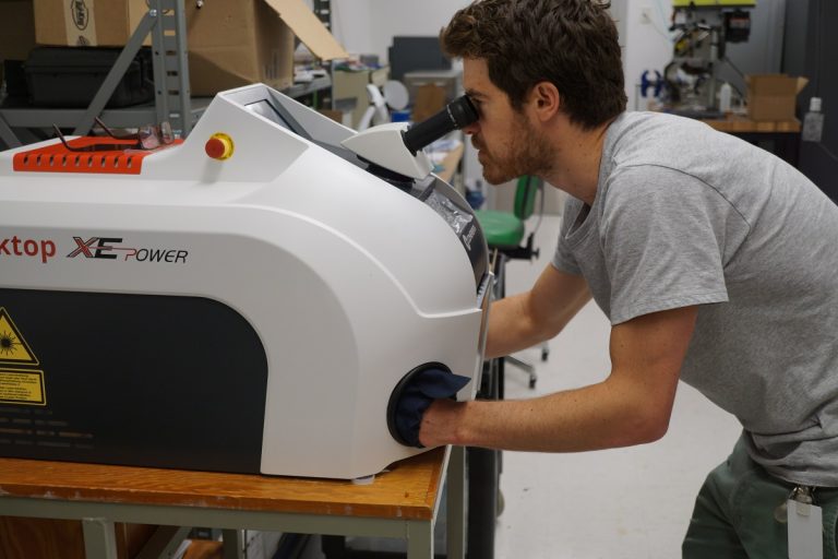 David Rutledge from Phase Sensors is laser welding the stainless steel face shield frame together using a Rofin Laser Welder in the machine photo.