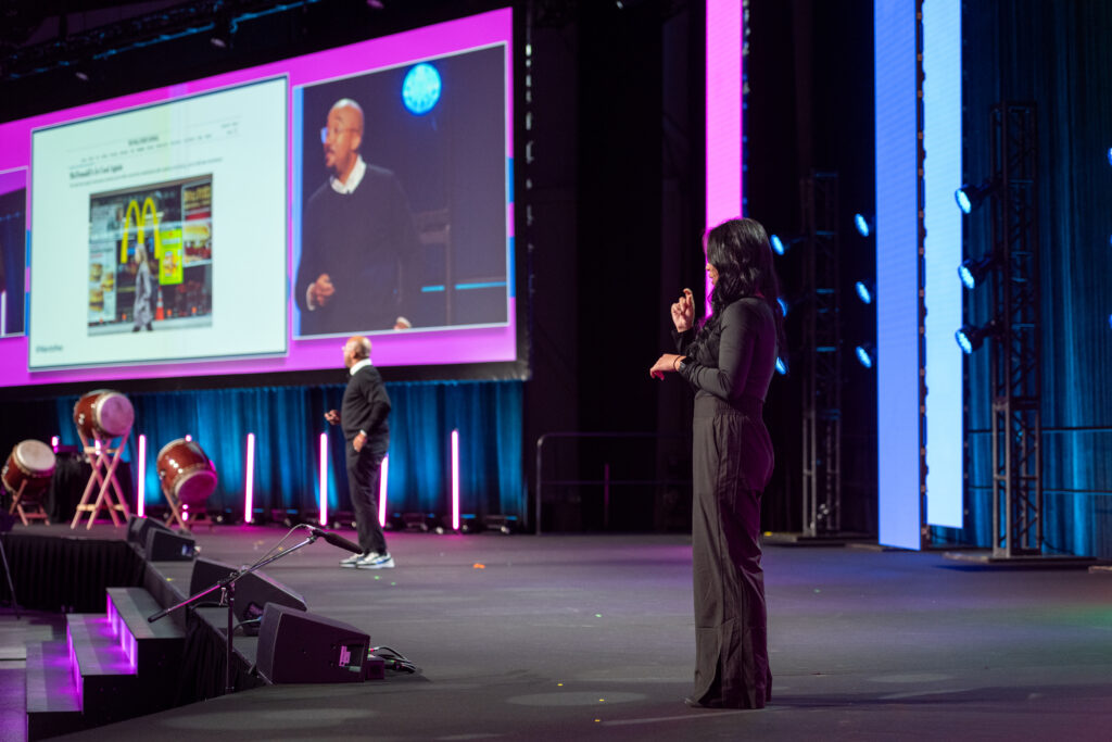 A picture of Marcus Collins on stage speaking at Inventures