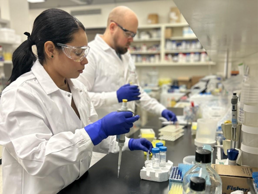 Two researchers with GlycoNet conduct testing in their laboratory at the University of Alberta.